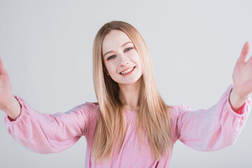 Portrait of young blonde woman with hug gesture in studio on white background