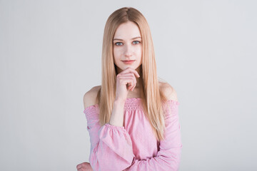 Portrait of a blonde girl who made a pensive look in the studio on a white background