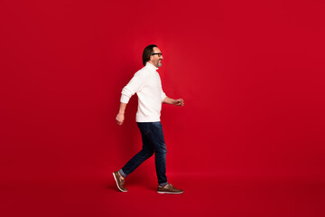 Fototapeta na wymiar Full length body size side profile photo of aged man walking hurrying up on meeting isolated on red color background