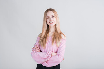 Portrait of a blonde girl who crossed her arms in the studio on a white background