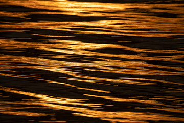 The picture of the golden sea water surface reflecting the sunlight