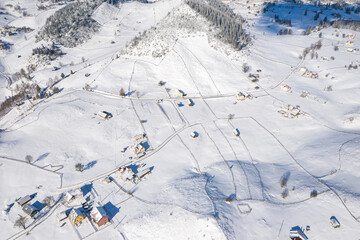 Fototapeta na wymiar Aerial scenic rural view of the winter landscape from Fundata village in Romania at the bottom of Bucegi Mountains 
