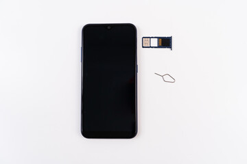 smartphone, sim card in tray and key clip to fetch on a white background. subscriber's electronic module used in mobile communications.