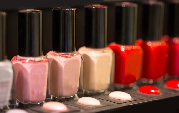 Nail polish set on the shelf in different shades of red and pink. Choosing varnish loya nails in the store.