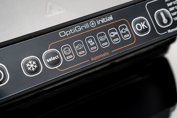 control panel on a black background. electric grill with closed lid. appliance for cooking in...