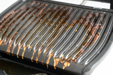 dirty after cooking electric grill with open lid. appliance for cooking in everyday life. Made of...