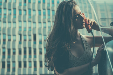 Old fashion town. Vintage concept. Oldstyled city. Woman with payphone. Communication.