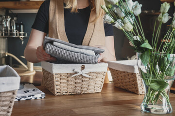 Girl spring cleaning in the kitchen. Piles kitchen towels in baskets. Spring cleaning,...