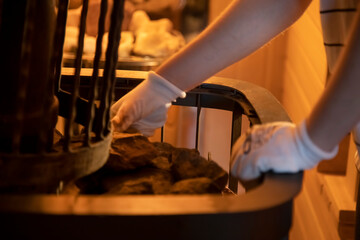the hands of the master lay stones in the sauna stove