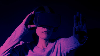 Girl with hands up wearing the VR headset goggles. Asian woman in glasses of virtual reality. The...