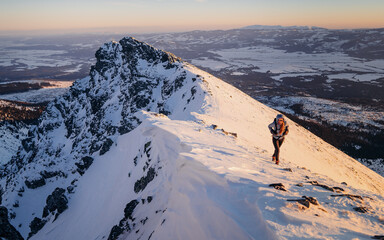 Hiker hiking in mountain range background banner - Climbing woman mountain climber wearing hood...
