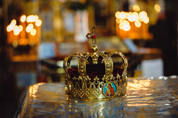 Classic wedding ceremony, golden crown in the old church. Rich wedding crown decorated with precious stones, closeup. Film noise