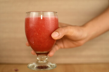 hand holding glass of  water melon juice 