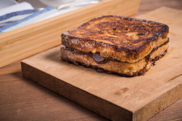 Ready fried french toast on wooden board in home kitchen