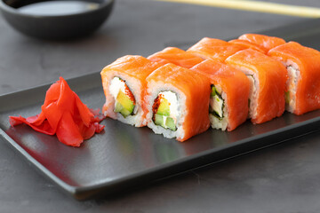 Philadelphia sushi roll served on black ceramic plate