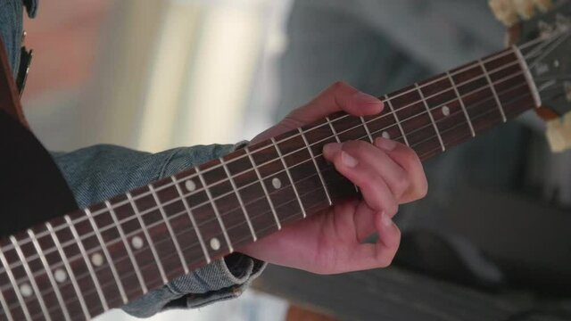 Close up of a guitar while someone is playing
