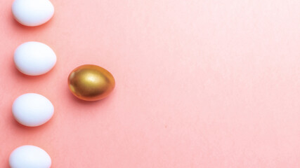 Easter gold. Golden, white colour egg on pastel pink background in Happy Easter decoration. Traditional design in top view.