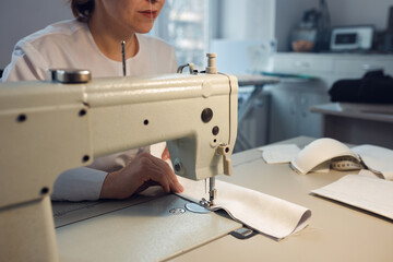 young girl seamstress while working on tailoring in her workshop