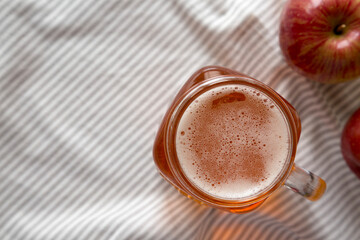 Hard Apple Cider Ale in a Glass Jar Mug on cloth, top view. Flat lay, overhead, from above. Copy space.