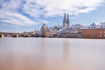 Obraz premium Hochwasser des Flusses Donau im Winter 2021 in Regensburg mit Blick auf den Dom die Altstadt und überschwemmte Promenade und der steinerne Brücke, Deutschland