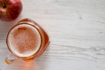 Hard Apple Cider Ale in a Glass Jar Mug on cloth, top view. Flat lay, overhead, from above. Space for text.