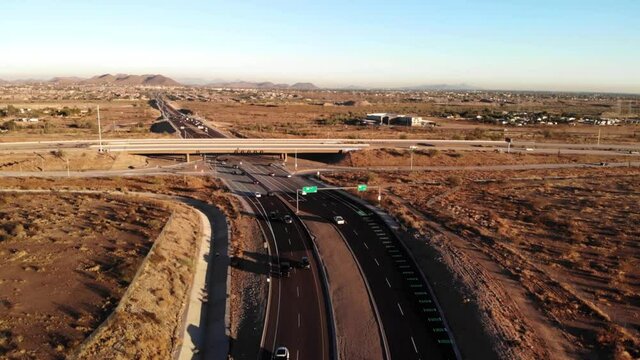 Low altitude drone approach to the 303 overpass of Happy Valley Rd Peoria Arizona desert view.