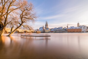 Fototapeta na wymiar Hochwasser des Flusses Donau im Winter 2021 in Regensburg mit Blick auf den Dom die Altstadt und überschwemmte Promenade und der steinerne Brücke, Deutschland
