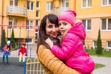 Mother with girl at playground. Woman holding she