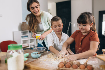 Obraz na płótnie Canvas kids baking with their mother at home