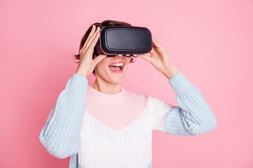 Photo portrait of amazed girl in vr-headset isolated on pastel pink colored background