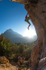 woman and man are engaged in rock climbing on vacation