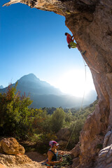 woman and man are engaged in rock climbing on vacation