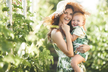 Young mother and her little daughter outdoors having fun. Pretty family. Girls leisure
