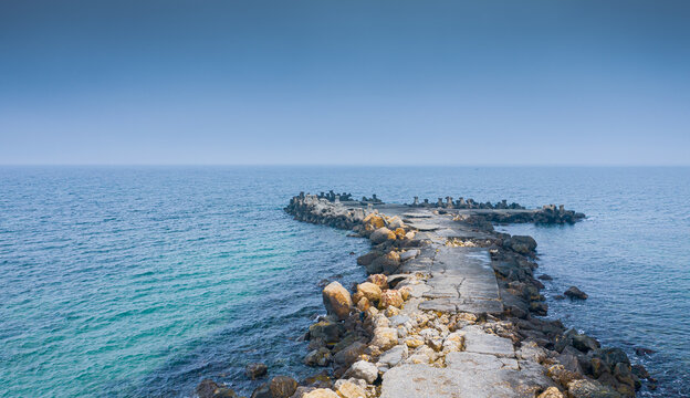 Aerial view of a dock with stabilopods rocks in the Black Sea during a cloudy day