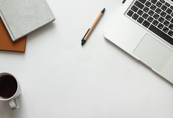 Freelancer desk with macbook on white background near notepad and pen