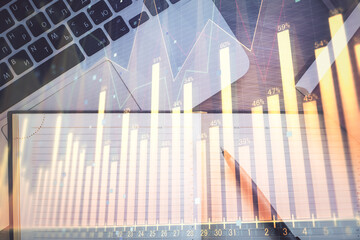 Stock market graph and top view computer on the table background. Multi exposure. Concept of financial education.