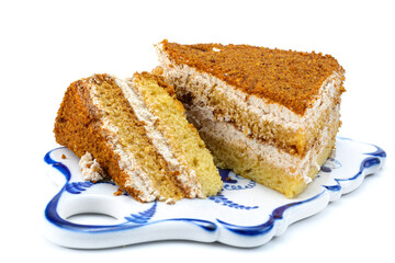 Cake, a slice of delicious honey cake. A piece of cake on a porcelain platter. Isolated on a white background is a sweet dessert. selective focus.