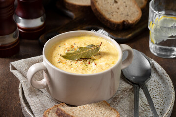 The cream of chicken soup. Puree soup chicken, carrot and onion soup with cream. Chicken soup in a bowl on a brown wooden table