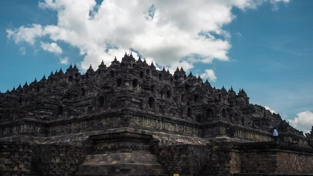 Central Java, Indonesia, zoom out timelapse view of tourists visiting the ancient ruins of Borobudur, a 9th-century Mahayana Buddhist temple in Magelang Regency near Yogyakarta.