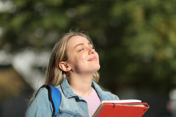 Happy student breathing fresh air in a park