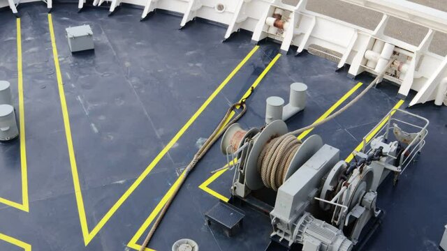 Mooring rope being winched back on deck using an electric winch before departure