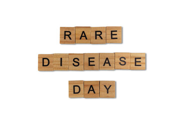 Top view of the word rare disease day laid out from square wooden tiles isolated on white background. World and international day.