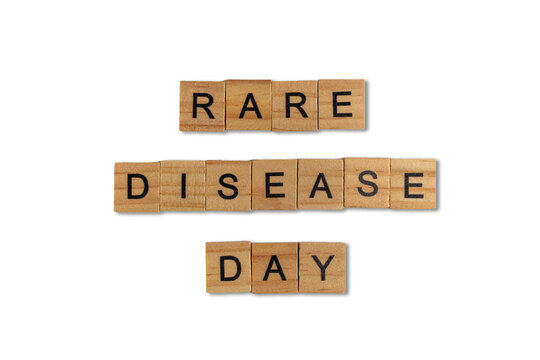 Top view of the word rare disease day laid out from square wooden tiles isolated on white background. World and international day.