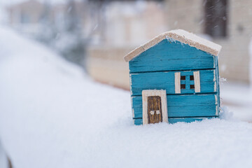 colored wooden model house in snow