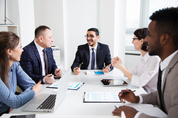 Group of multi-ethnic business people sitting around the office desk and discussing the project