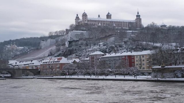View of the River Main, Festung Marienberg, K&auml;ppele and the Alte Mainbr&uuml;cke on a cold gray winter day in W&uuml;rzburg. This beautiful historical german city is very rarely coverd in snow. 4K, left to righ