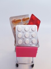 Food cart with pills on white background. Concept of medicine, treatment, use, purchase and sale of medicines.