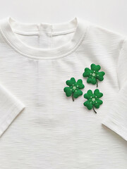 Handmade clover leaf brooch on white T-shirt. Celebrating Saint Patrick's Day Concept