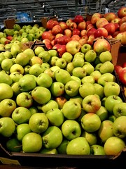 Lots of red and green apples in a supermarket showcase close up