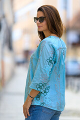 Young beautiful woman dressed in fashion clothing posing on the street